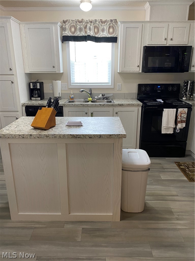 2700 Brookpark Road, Unit 626 Cleveland, OH 44134 - Photo 4 of 32 Kitchen with range, a center island, sink, white cabinetry, and ornamental molding