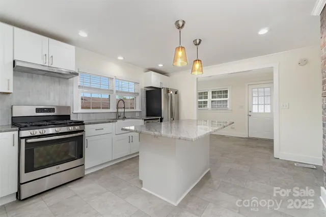 a kitchen with stainless steel appliances granite countertop a stove and a sink