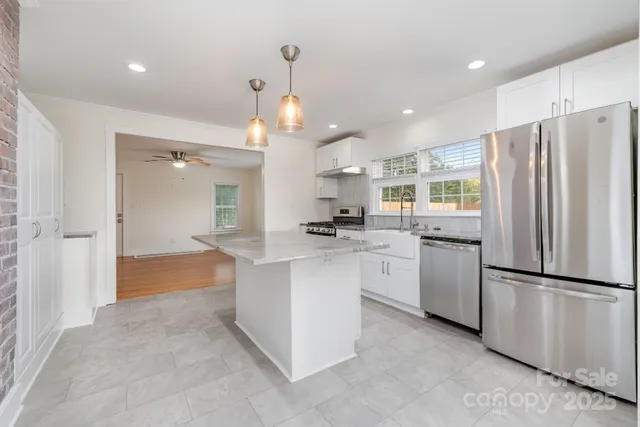 a kitchen with white cabinets and stainless steel appliances