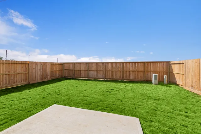 a view of a backyard with wooden fence