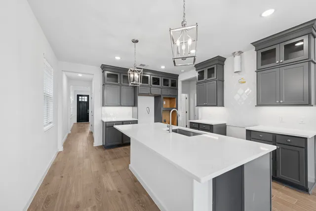 a large white kitchen with cabinets a sink and a stove