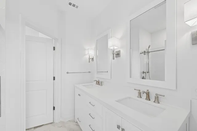 a bathroom with double vanity sink and two mirror
