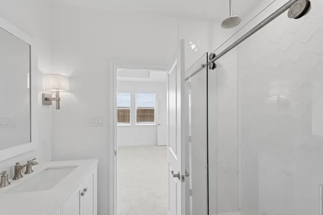 a bathroom with a shower sink and mirror