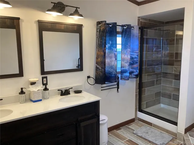 a bathroom with a double vanity sink mirror and shower