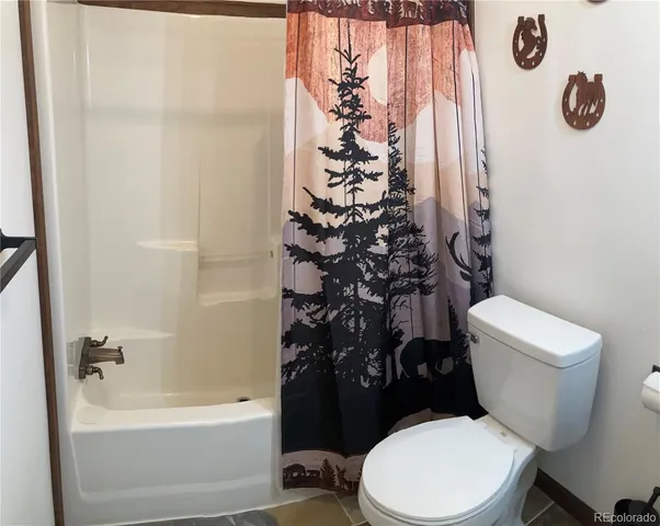 a white toilet sitting next to a bath tub