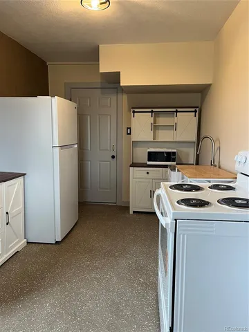 a kitchen with a stove top oven and refrigerator