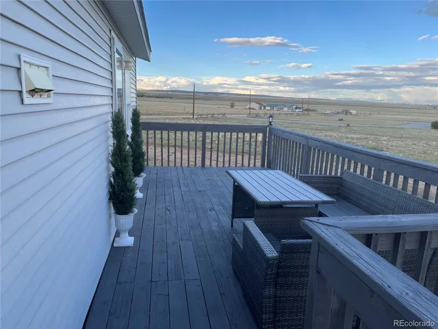 a view of a roof deck with wooden floor and fence