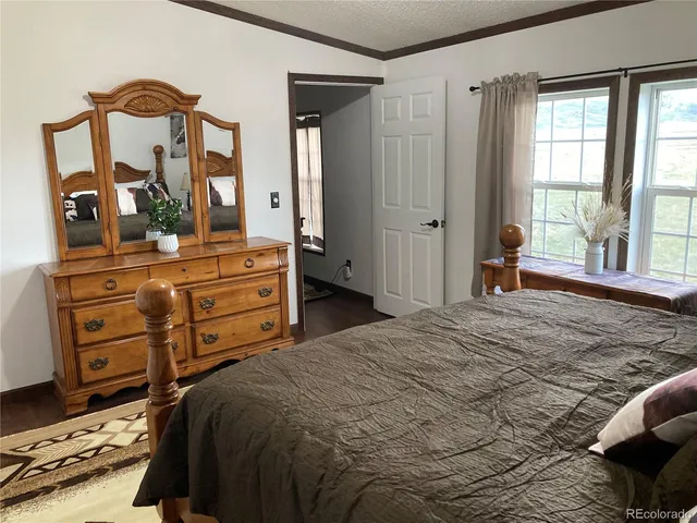 a bedroom with a bed and a mirror on dresser