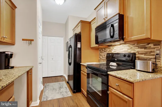 a kitchen with stainless steel appliances granite countertop a stove microwave and refrigerator