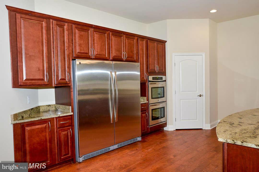 8536 Old Keene Mill Road Springfield, VA 22152 - Photo 7 of 30 a kitchen with granite countertop stainless steel appliances a refrigerator and wooden cabinets