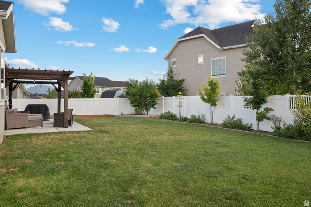1074 South 750 West Springville, UT 84663 - Photo 26 of 28 Expansive backyard featuring a manicured lawn, concrete patio, and a wooden pergola structure