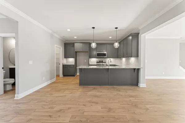 a large kitchen with kitchen island a sink stainless steel appliances and cabinets