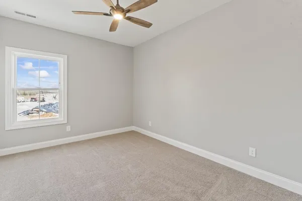 an empty room with a window and a fan