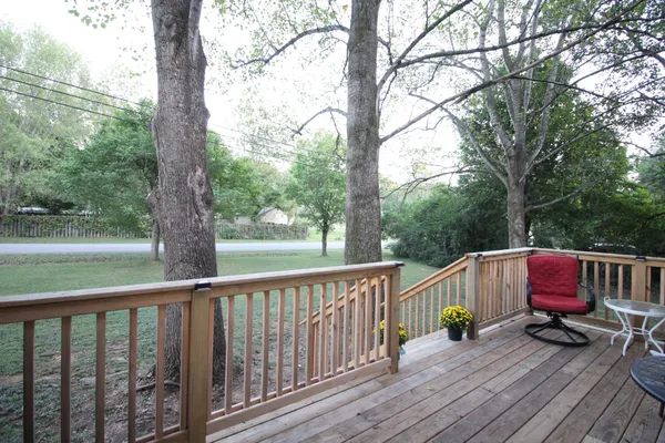 a kitchen with stainless steel appliances granite countertop a stove a sink dishwasher a refrigerator a dining table and chairs with wooden floor