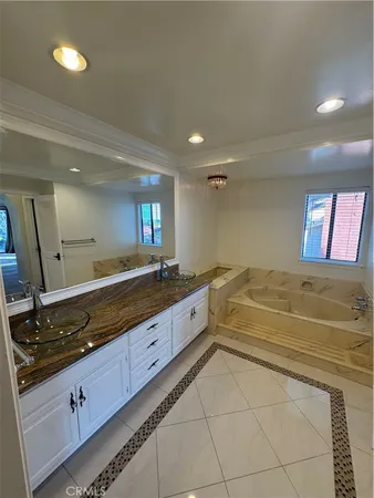a spacious bathroom with a granite countertop sink and a mirror