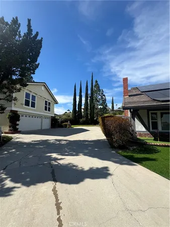 a view of street with house on its side with small yard