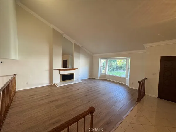 a view of empty room with wooden floor and fireplace