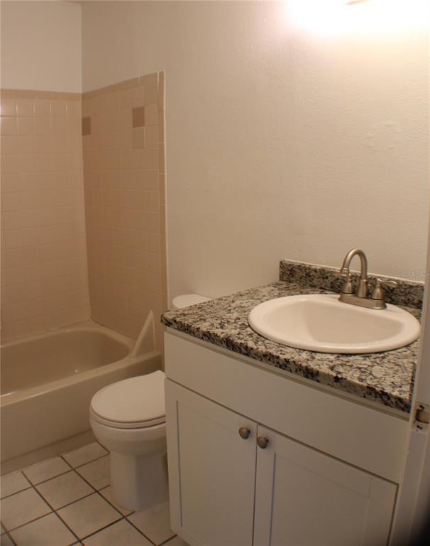 1194 Falcon Drive, Unit 14 Dunedin, FL 34698 - Photo 11 of 20 a bathroom with a granite countertop sink toilet and shower