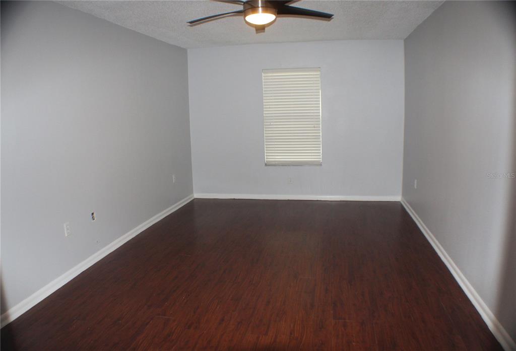 1194 Falcon Drive, Unit 14 Dunedin, FL 34698 - Photo 14 of 20 an empty room with wooden floor and windows