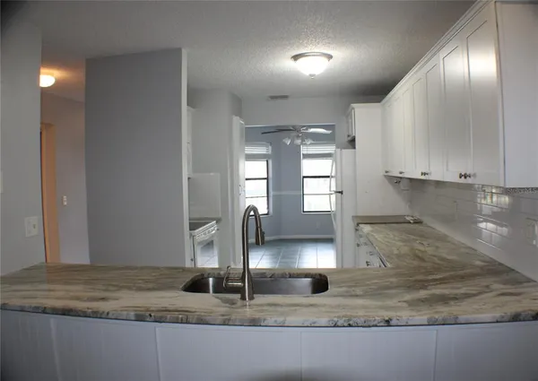 a kitchen with kitchen island a counter top a sink and a window