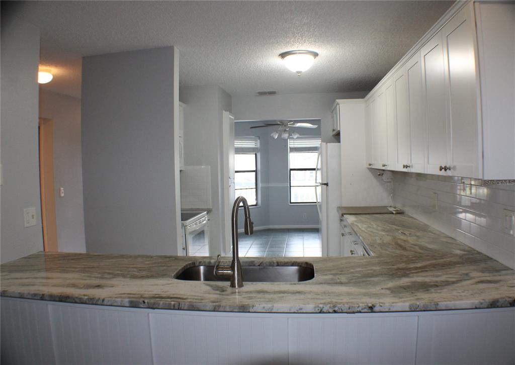 1194 Falcon Drive, Unit 14 Dunedin, FL 34698 - Photo 15 of 20 a kitchen with kitchen island a counter top a sink and a window