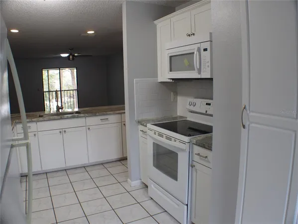 a kitchen with white cabinets appliances and sink