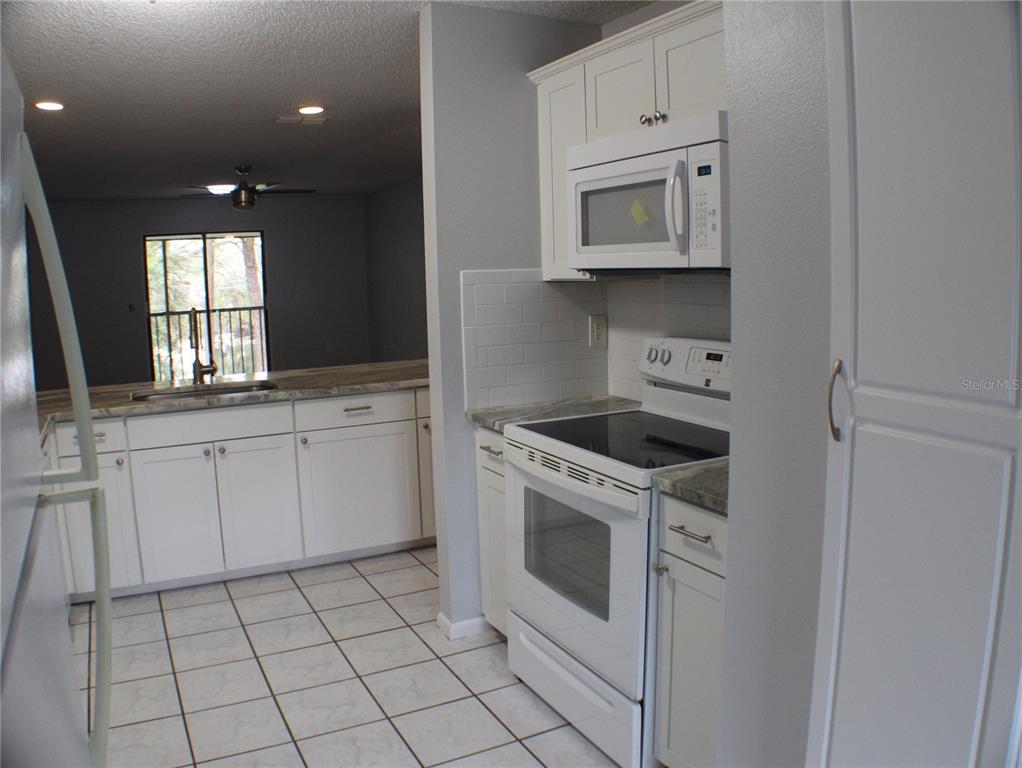 1194 Falcon Drive, Unit 14 Dunedin, FL 34698 - Photo 16 of 20 a kitchen with white cabinets appliances and sink