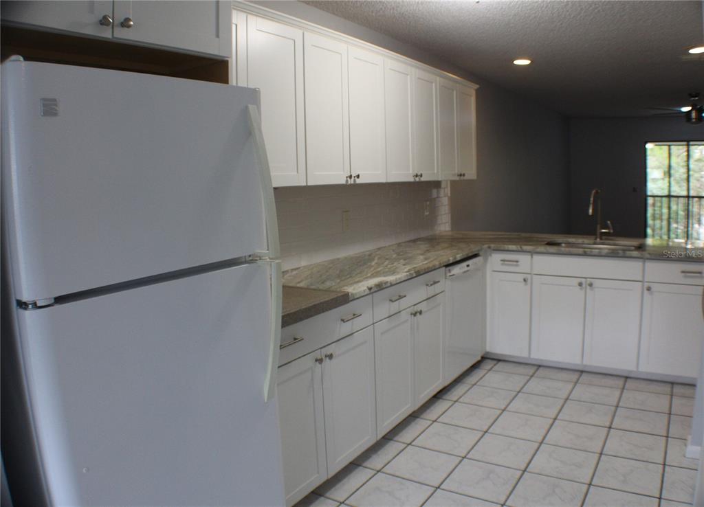 1194 Falcon Drive, Unit 14 Dunedin, FL 34698 - Photo 17 of 20 a kitchen with white cabinets and white appliances