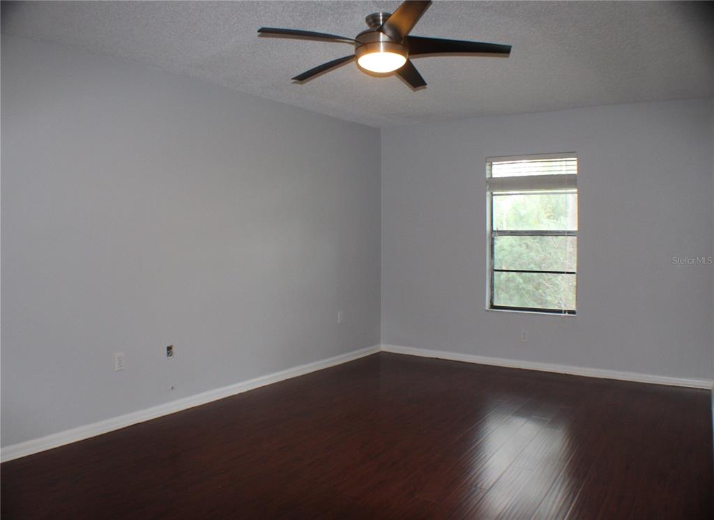 1194 Falcon Drive, Unit 14 Dunedin, FL 34698 - Photo 2 of 20 a view of an empty room with wooden floor and a window