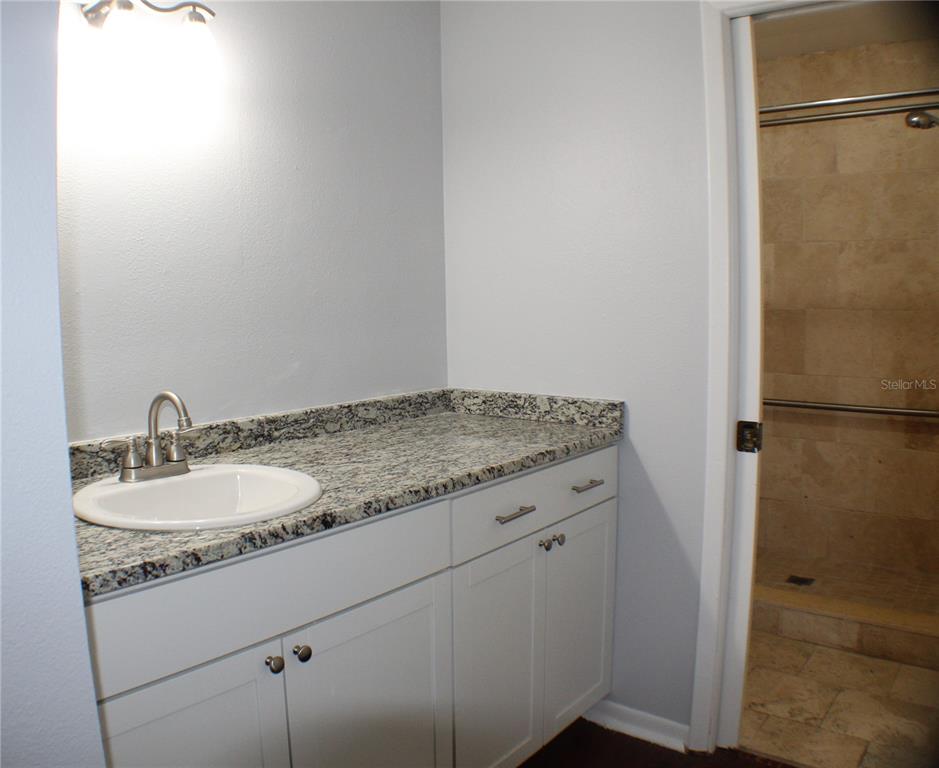 1194 Falcon Drive, Unit 14 Dunedin, FL 34698 - Photo 4 of 20 a bathroom with a granite countertop sink and a mirror