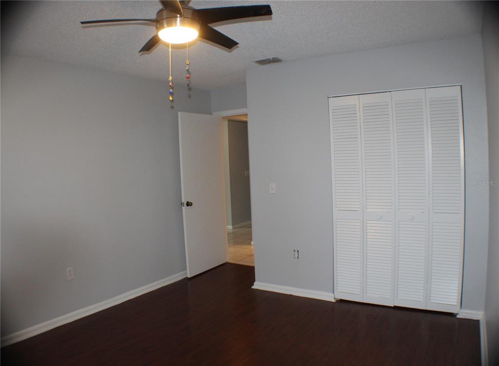 1194 Falcon Drive, Unit 14 Dunedin, FL 34698 - Photo 8 of 20 an empty room with a chandelier fan and closet area