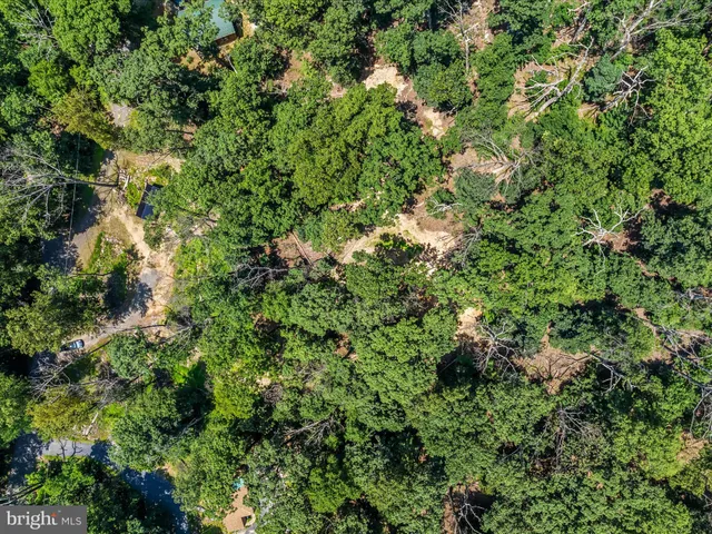 an aerial view of residential house with outdoor space and trees all around