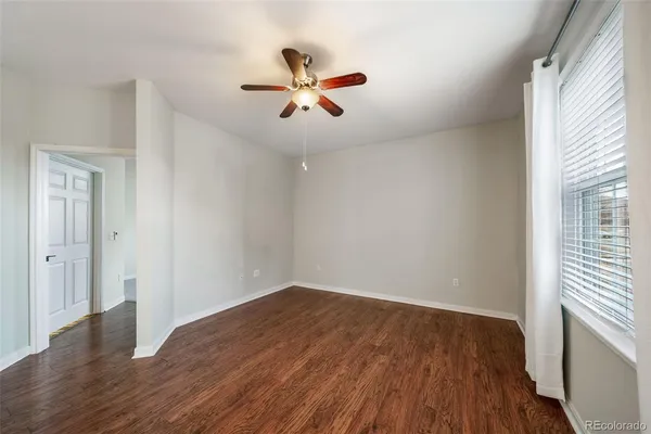 a view of a room with wooden floor and ceiling fan