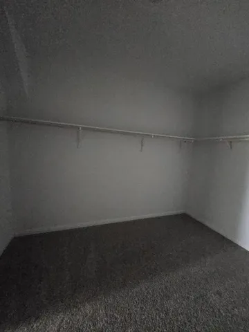 a bedroom with a bed a mirror and a large mirror on the dresser