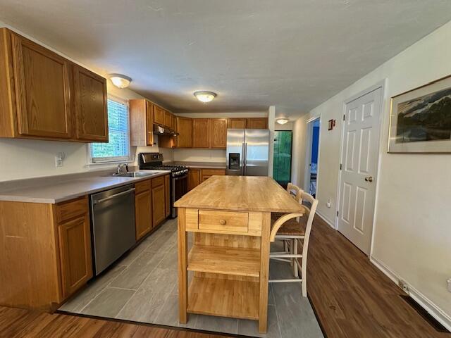 709 Old Barnstable Road Mashpee, MA 02649 - Photo 10 of 32 a kitchen with a refrigerator a sink dishwasher and wooden cabinets with wooden floor