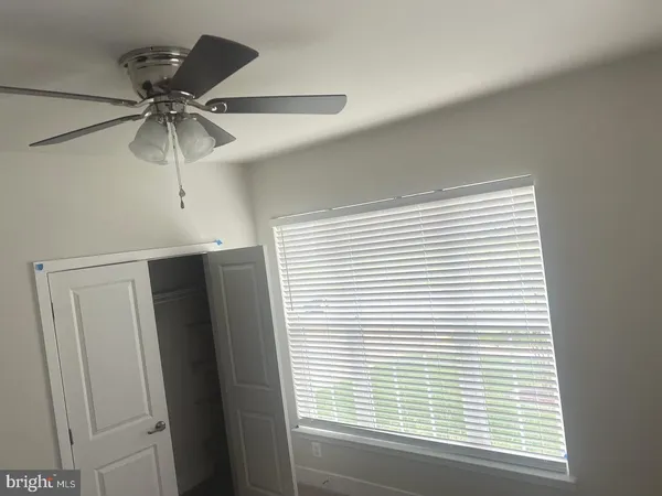 a view of a room that has a window and a ceiling fan