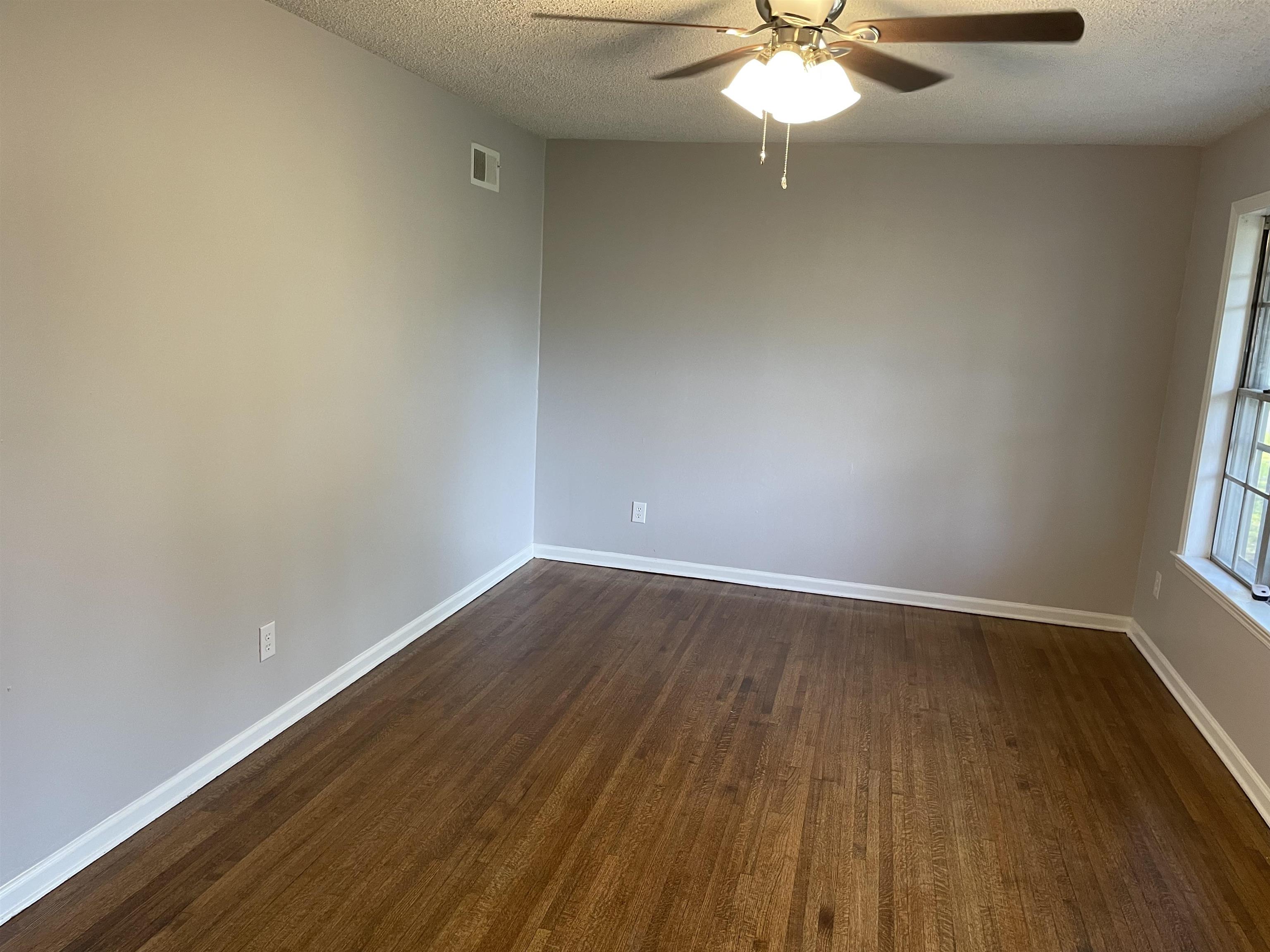 4615 Berta Road Memphis, TN 38109 - Photo 2 of 19 wooden floor in an empty room with a window
