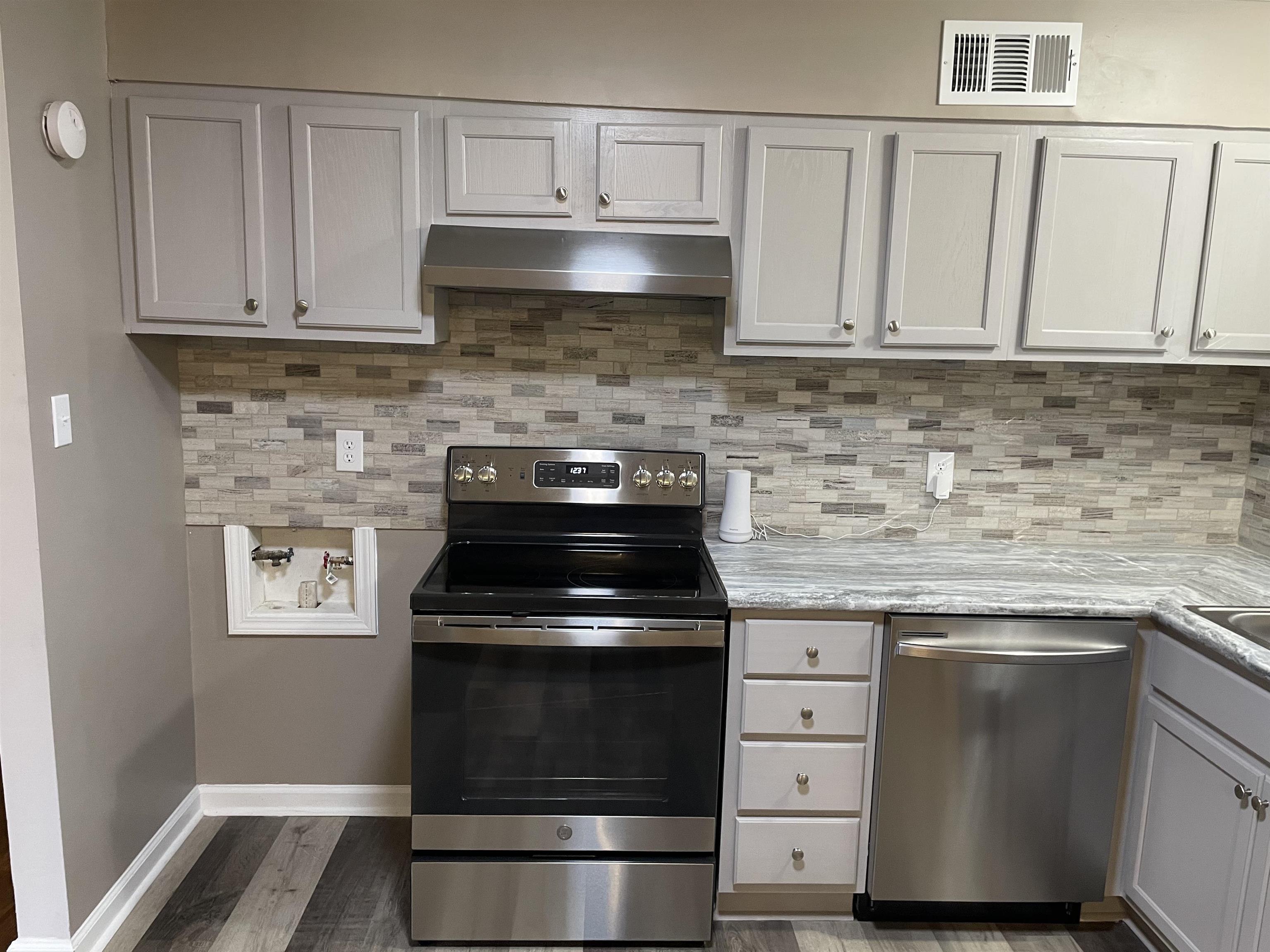 4615 Berta Road Memphis, TN 38109 - Photo 4 of 19 a kitchen with granite countertop white cabinets and stainless steel appliances