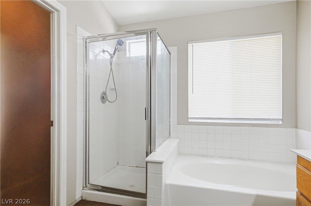 5100 Rancher Avenue Las Vegas, NV 89108 - Photo 20 of 26 Relax in the deep soaking tub or rinse off in the separate shower of this serene bathroom.