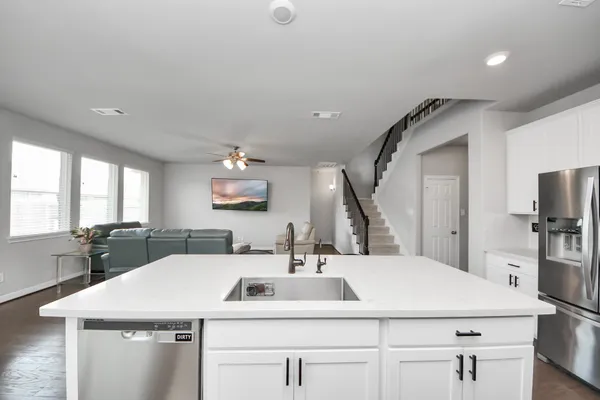 a room with a sink a large mirror and furniture