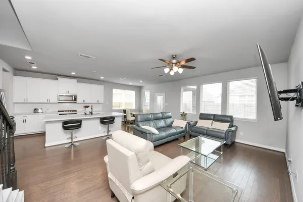 a living room with stainless steel appliances furniture and a view of kitchen