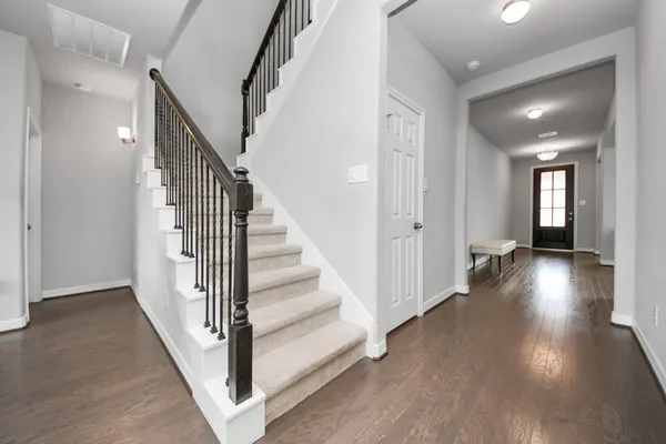 a view of a hallway with wooden floor and stairs