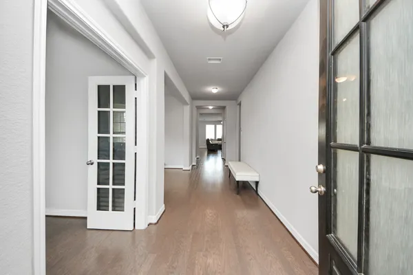 a view of a hallway with wooden floor and staircase