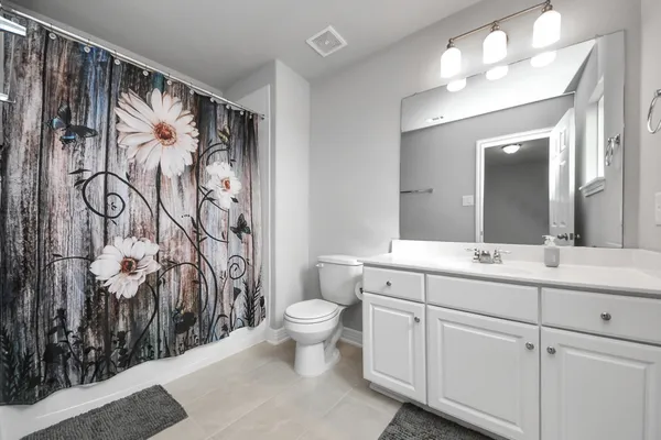 a bedroom with a bed and a flat tv screen on dresser