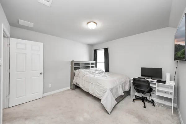 a bedroom with a bed and a large window