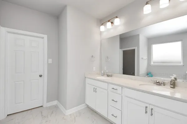 a spacious bathroom with a double vanity sink a mirror and a shower
