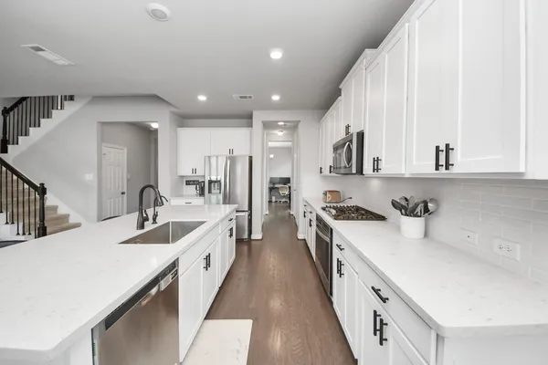 a large white kitchen with stainless steel appliances
