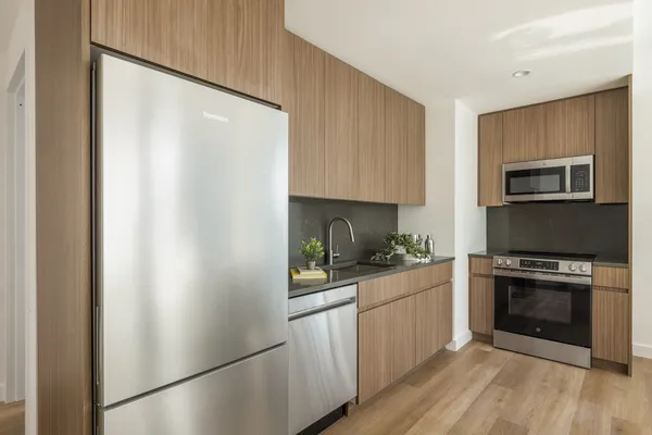 a kitchen with a refrigerator a stove top oven a sink and cabinets