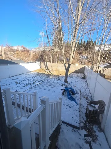 a view of a backyard with wooden fence