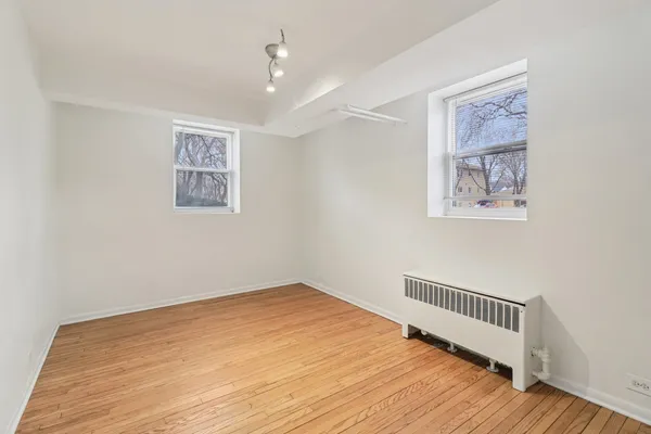 a view of an empty room with wooden floor